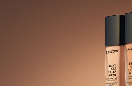 Base de maquillaje Lancome, presentando una gama de tonos y texturas para lograr una tez perfecta en un formato de escritorio.