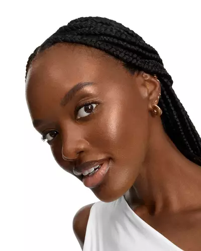 Mujer sonriente con trenzas largas y piel luminosa.