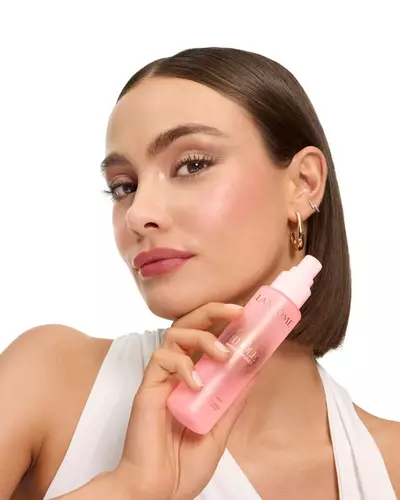 Mujer con corte bob sosteniendo la bruma Idole de Lancome.
