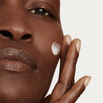 Primer plano de una modelo aplicando la crema Nutrix