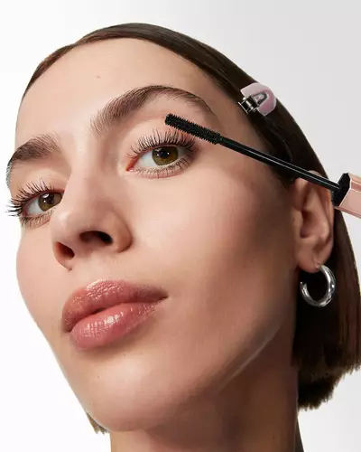 Mujer con la mascara Lash Idole Flutter Extension en la mano